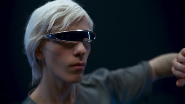 Thoughtful user examining checking VR technologies closeup. Blonde man headset exploring metaverse, touching considering virtual reality subjects slow motion. Digital modern high-tech world concept  - Felvétel, videó