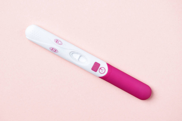 Pink positive pregnancy test on pink background. Positive result of pregnancy test. - Foto, afbeelding