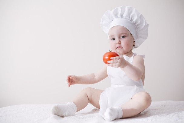 cute little cook eats tomato - Foto, Imagem