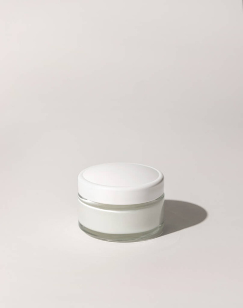 Cosmetic jar with a lid on white close up, mockup. Cosmetic packaging Mockup. Natural homemade cosmetics, monochrome composition, everyday skincare routin - Photo, Image