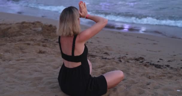 Yogi γυναίκα πρακτική γιόγκα και διαλογισμό σε στάση λωτού στην παραλία. Υγιές κορίτσι κάθεται σε στάση λωτού και διαλογισμό και εξάσκηση γιόγκα - Πλάνα, βίντεο