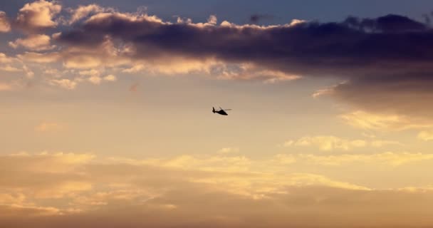 Ελικόπτερο που φέρουν στον ουρανό κατά τη διάρκεια γραφική ηλιοβασίλεμα με δραματικά σύννεφα, 4K βίντεο - Πλάνα, βίντεο