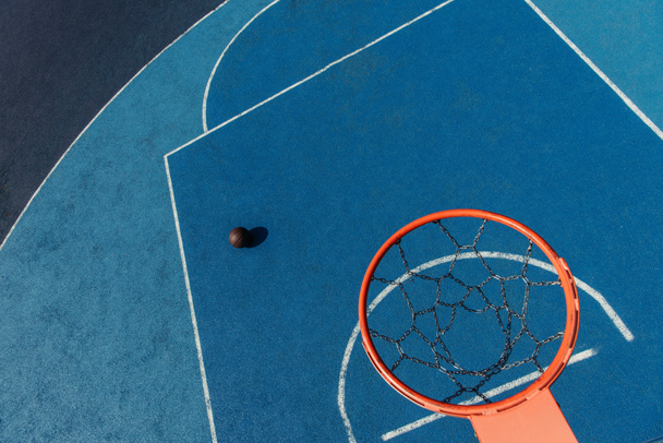 top view of basketball ring over ball on modern outdoor court - Zdjęcie, obraz