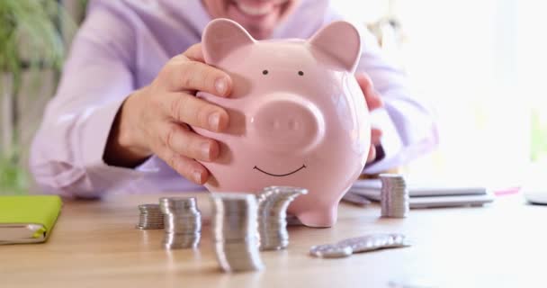 Happy man shakes piggy bank. Financial growth and profitable cash investment concept - Filmmaterial, Video