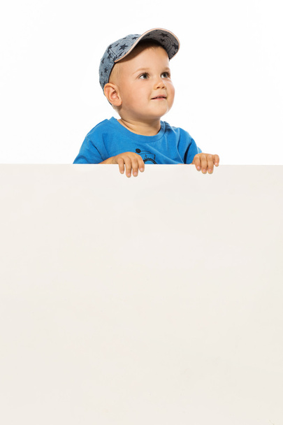Симпатичный маленький мальчик над белым пустым плакатом смотрит вверх
 - Фото, изображение