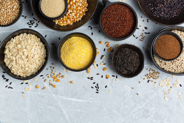 Healthy eating, dieting, balanced food concept. Assortment of gluten free cereals, corn, rice, amaranth, teff, buckwheat, quinoa and oat on a table. Top view flat lay background - Photo, Image