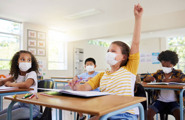 Learning, education and classroom in covid pandemic with students wearing face mask for protection against the spread of the virus or diseases. Clean inside school with dedicated and smart children. - Фото, изображение