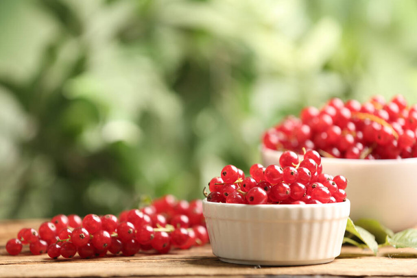 Ripe red currants on wooden table against blurred background. Space for text - Фото, изображение