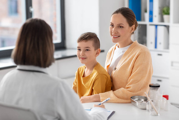 medicine, healthcare and pediatry concept - smiling mother with little son and doctor talking at clinic - Foto, Imagem