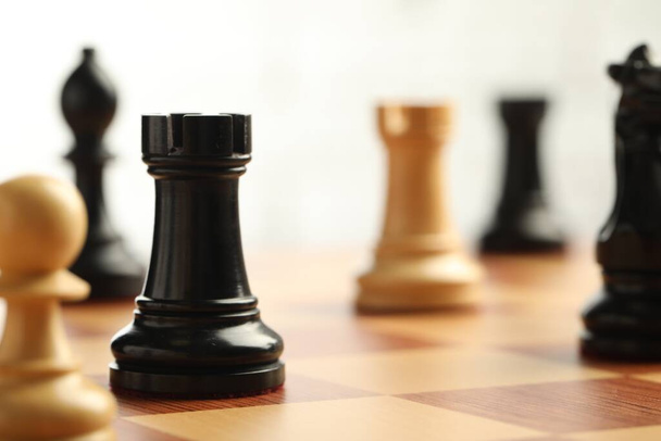 Chessboard with game pieces on light background, closeup. Space for text - Photo, Image