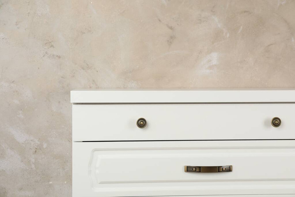 Modern chest of drawers near beige wall - Valokuva, kuva