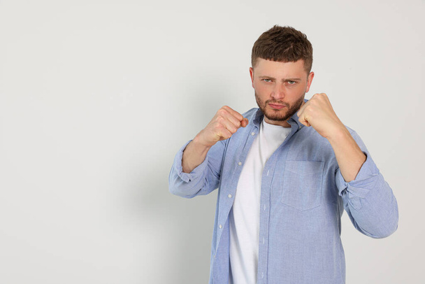 Young man ready to fight on white background, space for text - Foto, Imagem