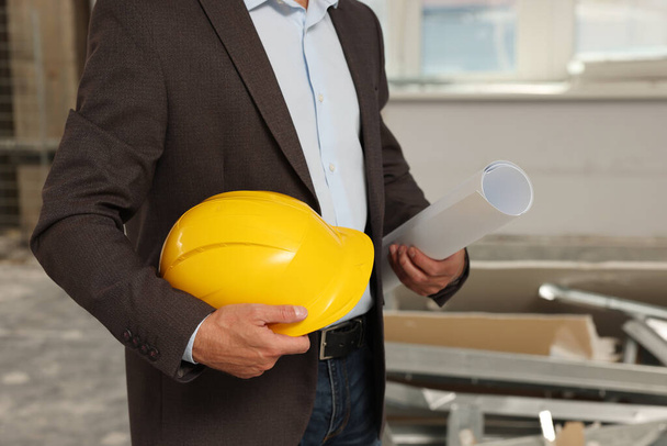 Professional engineer with hard hat and draft indoors, closeup - Fotoğraf, Görsel