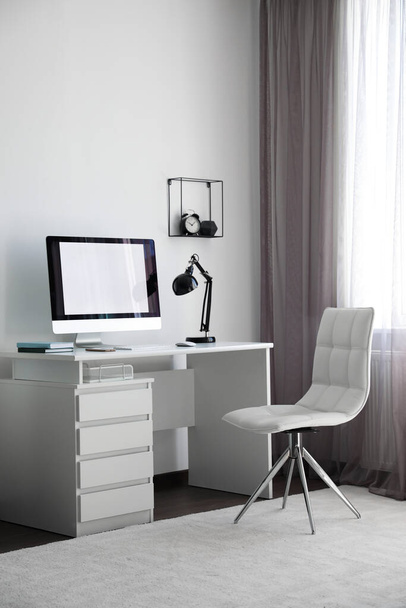 Comfortable white chair near desk in stylish office interior - Zdjęcie, obraz