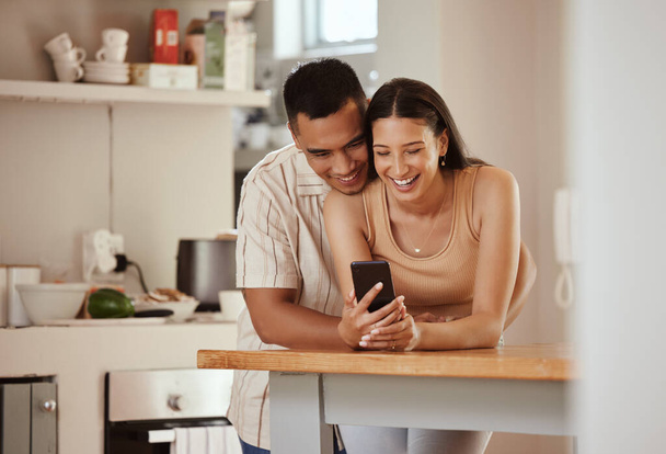 Happy, in love couple with a phone looking at funny content on social media, watching video or staying connected online. Bonding, romantic man and woman in relationship enjoying time together at home. - Foto, imagen