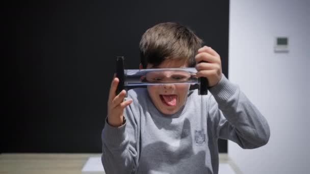 male child looking through glass celendric lens distorting eye display, science and development - Video