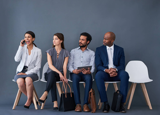 Did she get the job. Studio shot of a group of corporate businesspeople waiting in line against a gray background - Fotó, kép