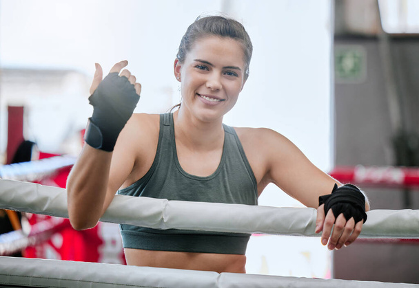 Active, fit and young female boxer ready for a boxing exercise, workout and training at a gym. Athletic, happy and sporty woman enjoying fitness and exercising at a sport and wellness studio or club. - 写真・画像