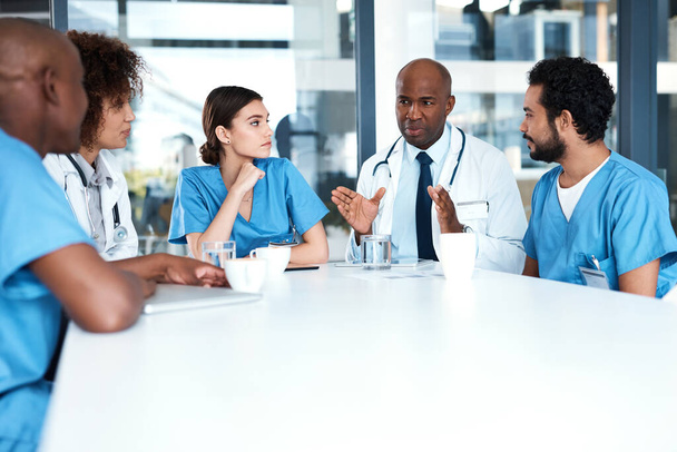 Planning the way forward. a group of medical practitioners having a meeting in a hospital boardroom - 写真・画像