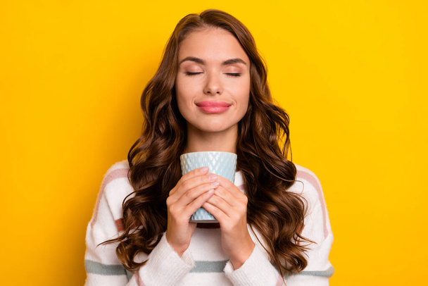 Portrait of gorgeous peaceful person closed eyes arms hold fresh hot coffee isolated on yellow color background. - Foto, Bild