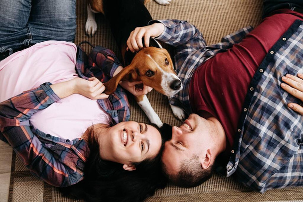 A woman, a man and a dog lie on the floor - Foto, afbeelding