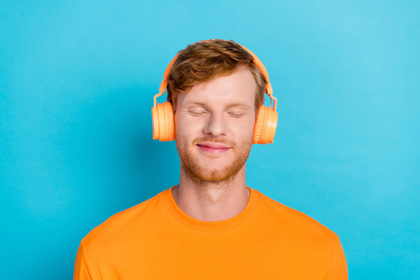 Close up photo of attractive boy wear trendy orange outfit clothes eyes closed enjoy nice music isolated on aquamarine color background. - Photo, Image