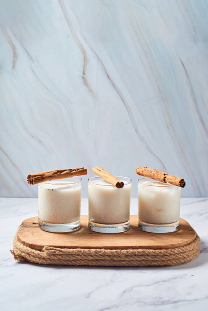 Fresh horchata with cinnamon in glass on rustic table - Foto, afbeelding