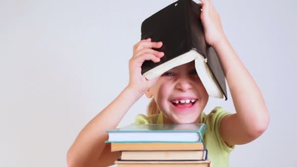 Little girl with book on head - Felvétel, videó