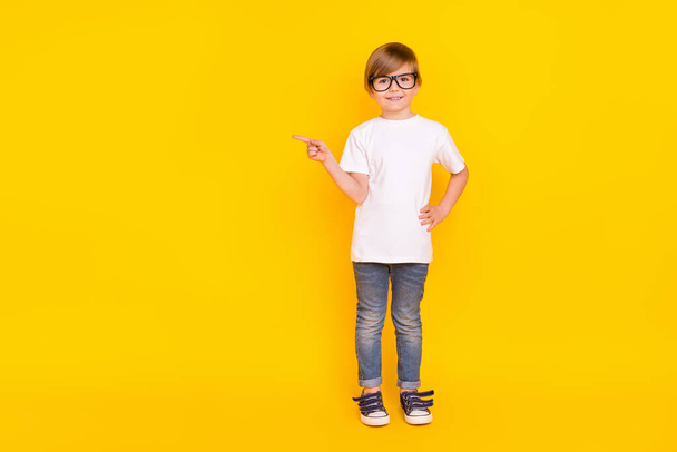 Full length body size view of handsome cheery trendy pre-teen boy showing ad idea isolated over bright yellow color background. - Photo, Image