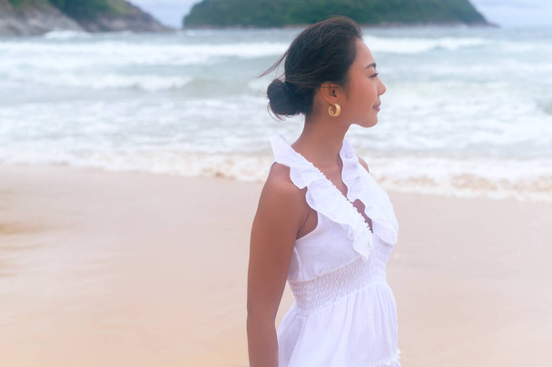 Beautiful young woman wearing white dress on the beach on holidays, travel, romantic, wedding concept - Foto, afbeelding