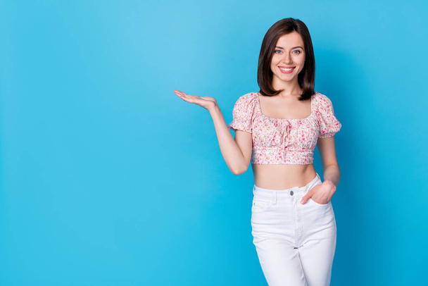 Portrait photo of young pretty cute nice girl wear stylish blouse hold hand demonstrating new app dating isolated on blue color background. - 写真・画像