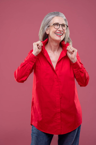 Feel good. Mature woman in red shirt looking contented - Foto, afbeelding
