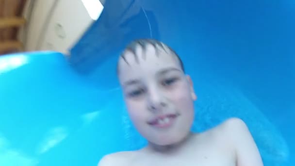 Chłopiec porusza się w dół ze wzgórza w aquaparku - Materiał filmowy, wideo