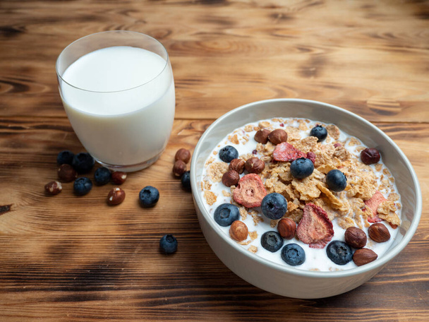 A cup with muesli and fresh berries on a wooden table. Healthy food, snack or breakfast. Healthy food. - Fotoğraf, Görsel