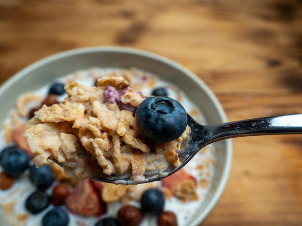 A cup with muesli and fresh berries on a wooden table. Healthy food, snack or breakfast. Healthy food. - Φωτογραφία, εικόνα