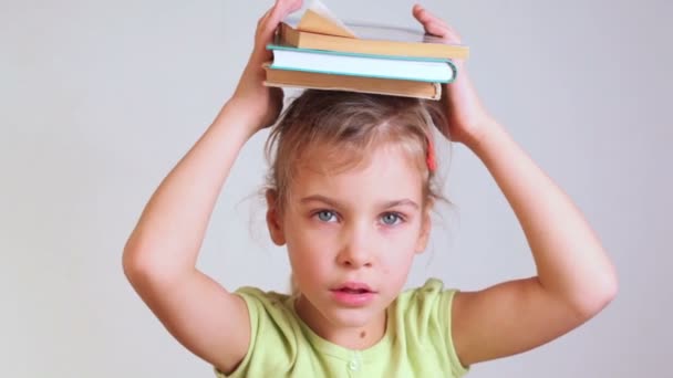 Little girl keeps books on head - Πλάνα, βίντεο