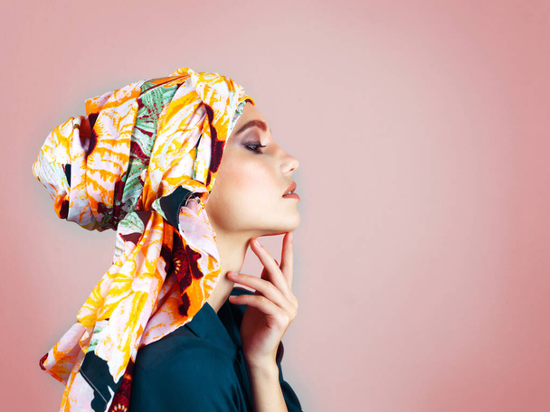 What can she be thinking about. Studio shot of a confident young woman wearing a colorful head scarf while posing against a pink background - Photo, image