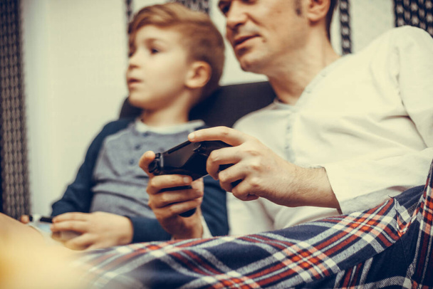 Close-up of father playing video games with his son at home. - 写真・画像