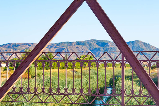 Nice landscape with an old metal bridge that crosses over the Segura River that carries water to irrigate the garden of Murcia - Foto, immagini