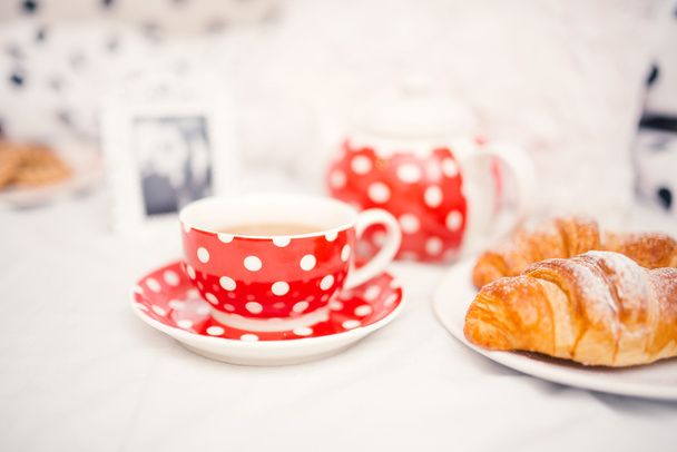 Delicioso e saboroso café fresco ou xícara de chá e croissants como lanche
 - Foto, Imagem