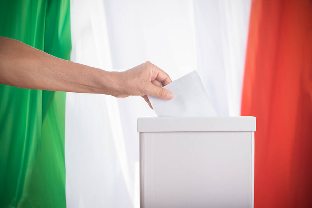Italian Vote. A close up of a woman hand putting blank ballot in box Democracy concept. - 写真・画像