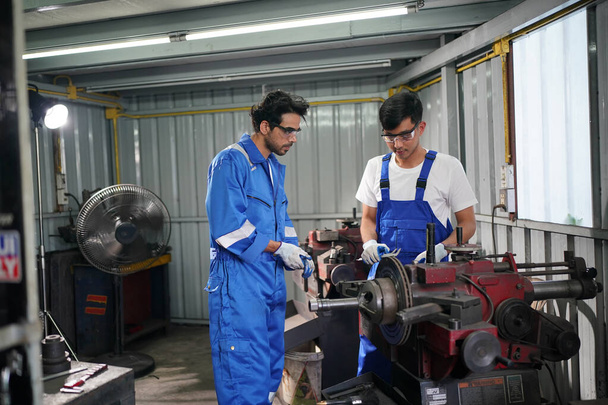 Рабочие меняют и ремонтируют колеса в автосервисе - Фото, изображение