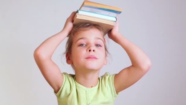 Little girl with books on head - Felvétel, videó