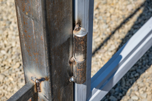 Metal hinge on the gate. A greasy loop when installing a metal structure. - Photo, image