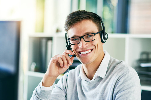 I might have just the solution for you. Portrait of a young call center agent working in an office - Foto, imagen