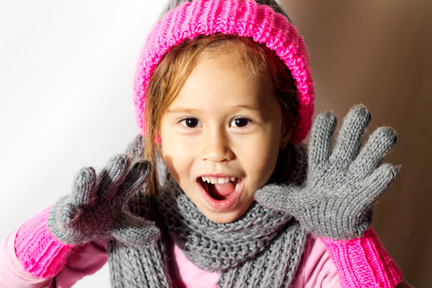 Маленька дівчинка в зимовому капелюсі з рукавичками і шарфом
. - Фото, зображення
