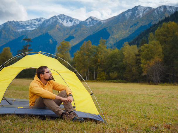 trip to Caucasus mountains, Arkhyz, Teberdinsky reserve. Man traveler relaxing in mountains in tent camping outdoor Travel adventure lifestyle concept hiking active vacations. - Zdjęcie, obraz