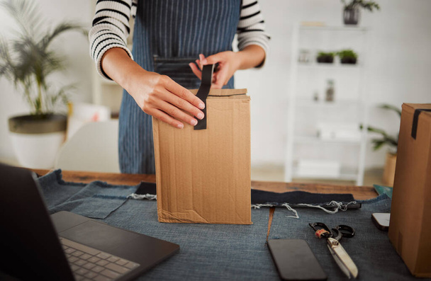 Packing parcel, package and shop order with duct tape while packaging, boxing and wrapping product. Small business tailor hands with laptop and clothing gift for courier shipping, selling or delivery. - Foto, imagen