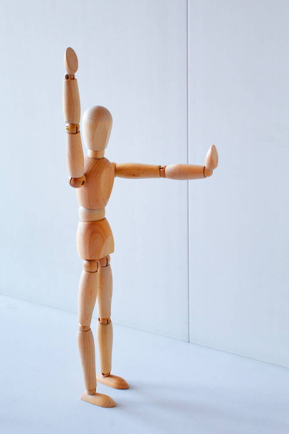 Concept of making the stop signal with the figure of a wooden boy - Fotoğraf, Görsel