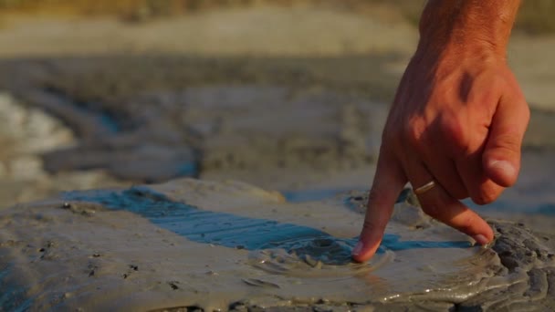 Human hand touching volcano mud - Πλάνα, βίντεο